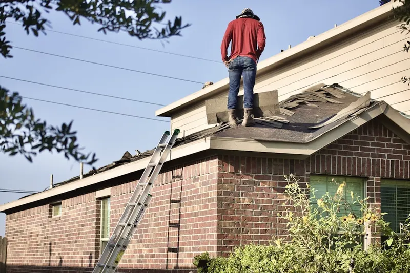 Professional roofer working on a residential roof in Southwest Village